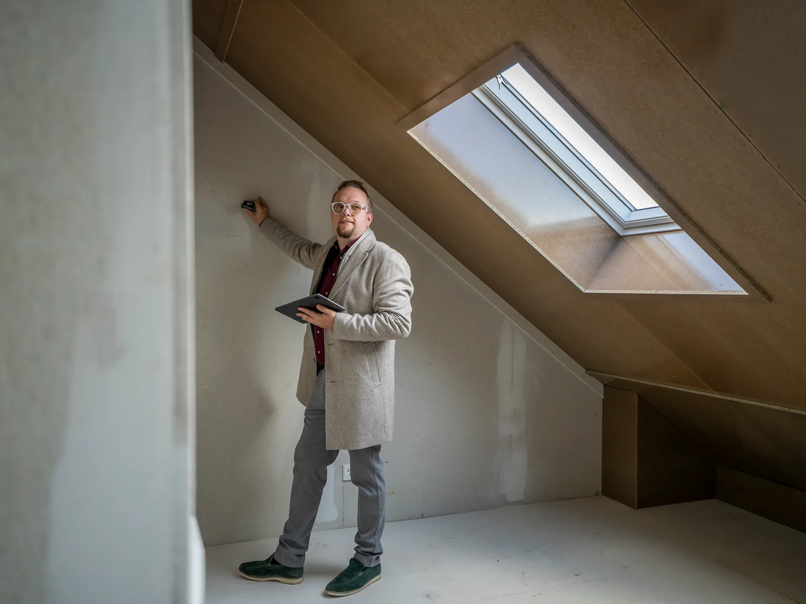 Mark Korbee aan het werk op een zolder onder een schuin dak met dakraam